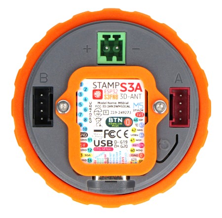 Inteligentne pokrętło M5Dial leży odwrócone na białym tle.