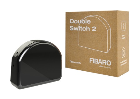 Czarny przekaźnik Fibaro Double Switch 2 leży na białym tle wraz z pudełkiem.